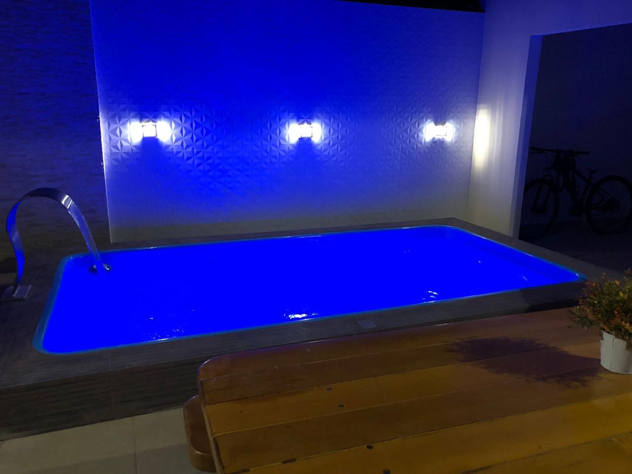 Piscina junto à área gourmet com cascata e iluminação LED